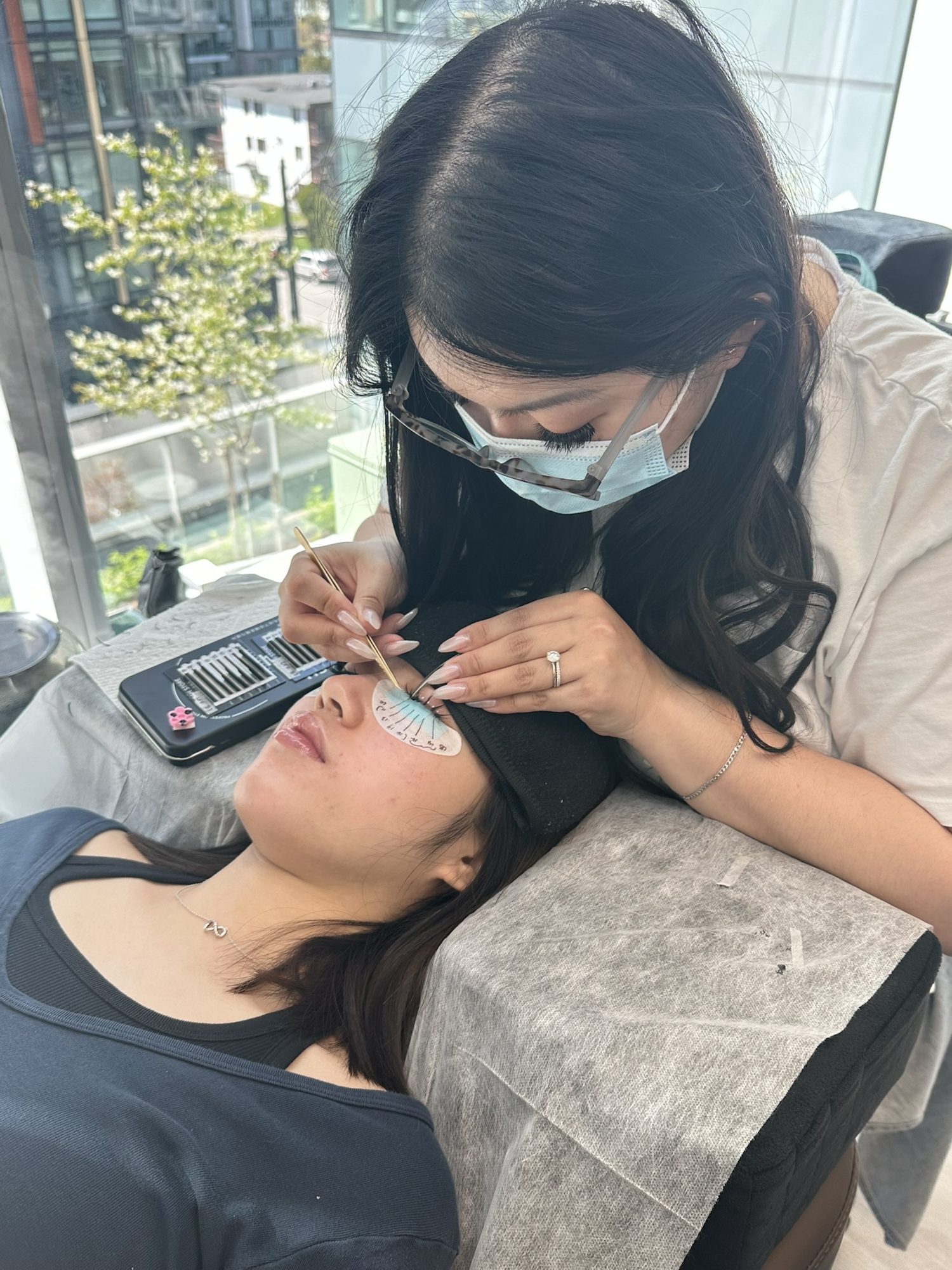 Samantha applying lash extensions to a client at Cilesia Beauty Bar